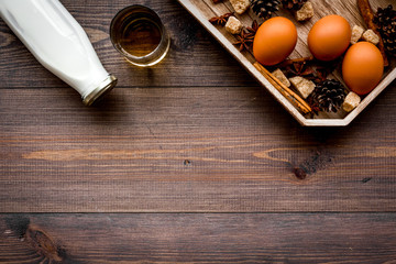 Ingredients for eggnog. Eggs, milk, cinnamon, whiskey on dark wooden background top view copyspace