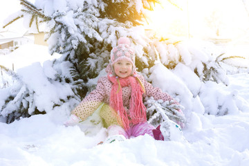 portrait of a girl in the winter with the sun in a fur hat. joyful girl, sunny winter