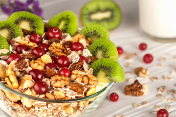 bowl of muesli with nuts of kiwi on  wooden background
