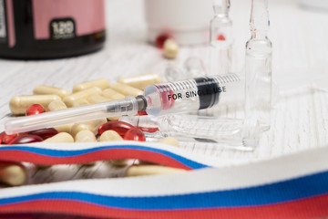 tablets, pills and syringe of doping drugs or medicine with russ