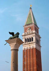 Fototapeta na wymiar Lion of Venice and San Marco Campanile - St Mark's bell tower in the St Mark's bell tower, located on the Piazza San Marco in Venice, Italy
