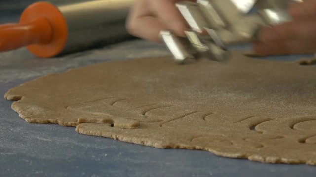 Woman cutting cookies with cutter, extreme closeup, dolly shot, ungraded