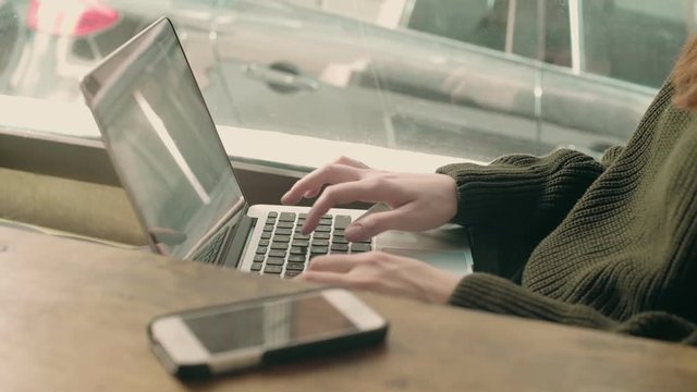 Soft focus shot of female professional freelance artist or business worker, work on computer, type code, project or text on laptop, remote office job in creative startup or coworking hub