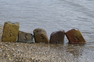 Fototapeta na wymiar old bricks on the sea shore