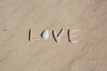 word Love from corals on sand of tropical beach