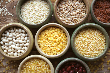 Bowls of various cereals in small containers on a wooden background, Cereal Mix, Beans, sesame, rice, pearl barley, wheat, Closeup, Selective focus