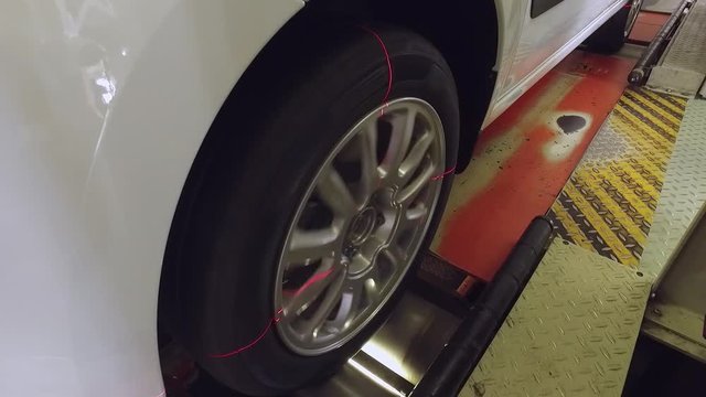 checking of a car wheel on an automobile factory, red laser level is shining
