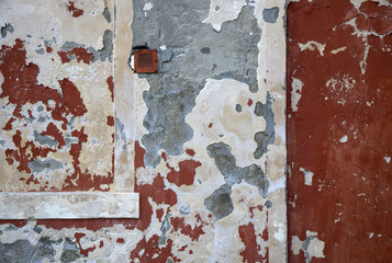 Hauswand mit abgeblätterter Farbe und Küchenabzugsabdeckung