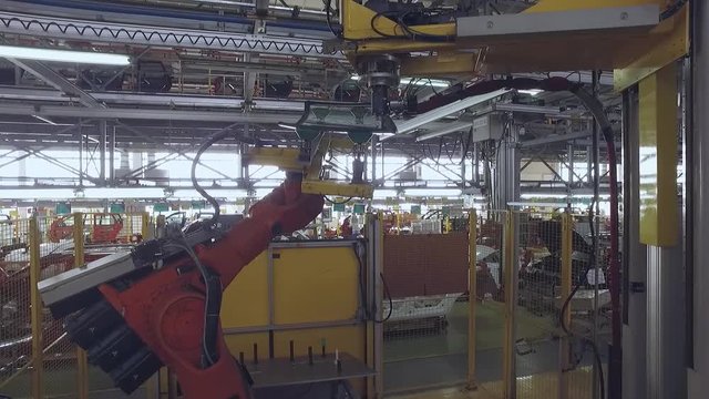 robot is giving a rear window of automobile for sealing machine in a car plant