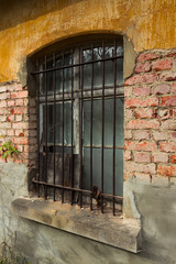 fenster hinter gitter und br&ouml;ckelnder fassade