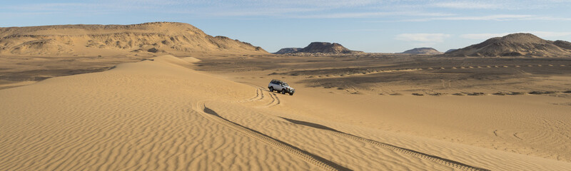 tourist jeep on excursion through the western desert sanddunes in Egypt