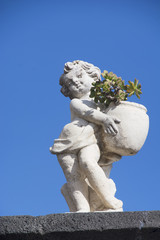 white cherub with green plant