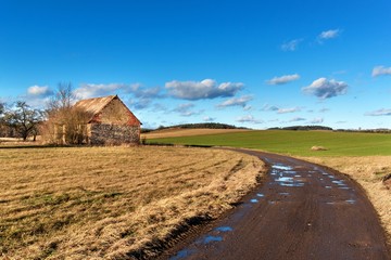 The muddy road in the countryside. Landscape of the Czech countryside. A sunny day on a farm.