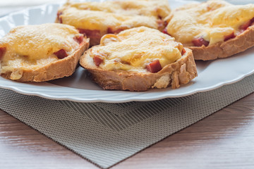 close-up of baked hot sandwiches with cheese and sausage on white plate