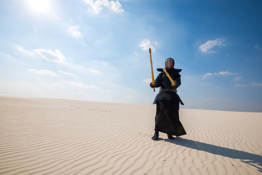 Man, in a traditional japanese armor is practicing kendo