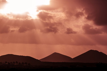 Romantic sunset at rock area. Volcanic area in Lanzarote national park. Mountain silhouette
