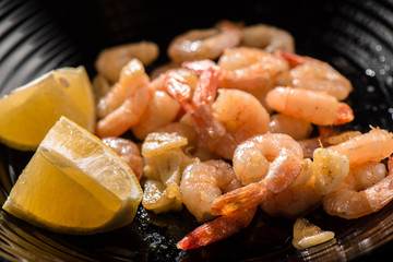 Roasted king prawns with garlic on a black plate