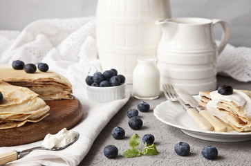 Baked fresh pancakes on a vintage wooden plate with fresh berries. Close-up, selective focus, shallow depth of field