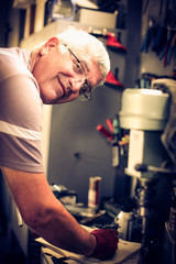 Senior smiling man writing obligations in his notes. Looking at camera.