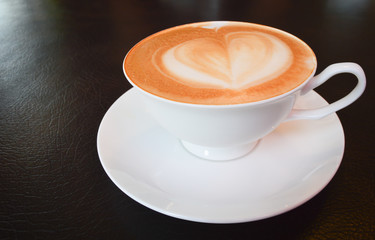 A cup of coffee with heart pattern in a white cup
