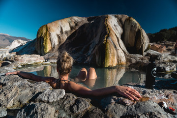 White female bathing in natural hot springs. - obrazy, fototapety, plakaty