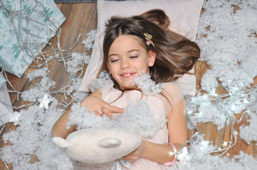 Portrait of little girl wait a New Year With Under a Christmas tree. Cute girl surrounded by Christmas lighting © Ivan