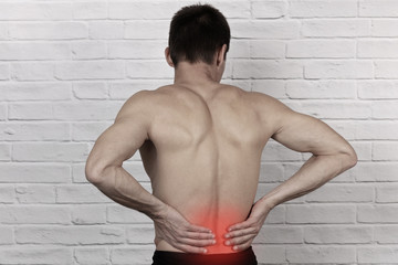 Obraz premium Muscular Man suffering from back and neck pain. Incorrect sitting posture problems, Muscle spasm, rheumatism. Pain relief , chiropractic concept. Sport exercising injury