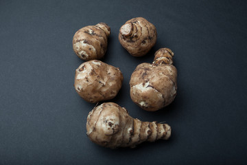 Tubers for breastfeeding or Jerusalem artichoke or Jerusalem artichoke (Helianthus tuberosus) isolated on a black background.