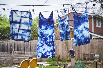 tie dyed clothes hanging on a clothes line.