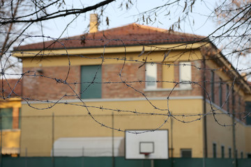 external view of a reformatory with a basketball court and barbed wire