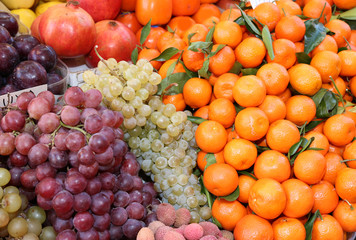 Naklejka na ściany i meble fresh fruit with grape tangerines and pomegranates for sale at the outdoor market
