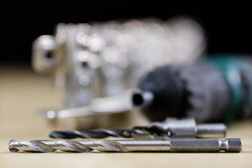 Carpentry tools and accessories on a workshop table. Hinges and screws together with the...