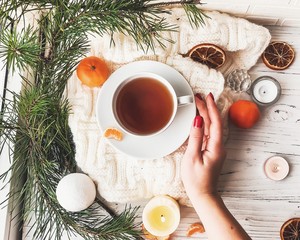 Winter breakfast. Tangerine and a cup of tea. Tree and the candles on the windowsill. Christmas morning 