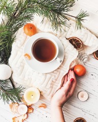 Winter breakfast. Tangerine and a cup of tea. Tree and the candles on the windowsill. Christmas morning 