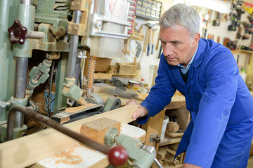 senior worker using tools in a workshop