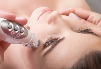 Obraz na płótnie Canvas Rejuvenating facial treatment. Model getting lifting therapy massage in a beauty SPA salon.
