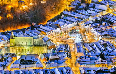 Brasov, Romania. Aerial view of the medieval city main square covered in snow with Christmas market and Xmas Tree, Transylvania, Eastern Europe.