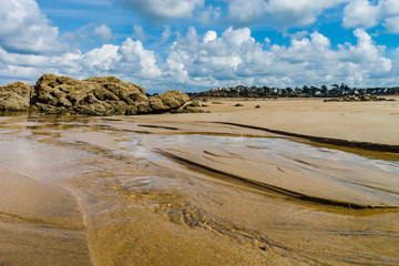 Low tide water on coastline, yellow sand of the beach, Bretagne