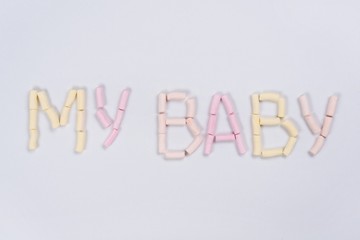 The word my baby is written by a pastel marshmallow on a white background. Backgrounds, textures.