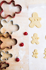 Preparing Christmas cookies as gift, christmas cutter witht the shape of people forming a family,   over a wooden table, top view.