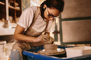 Fototapeta na wymiar Female potter making a clay bowl