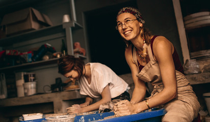 Two women a pottery workshop making clay pots
