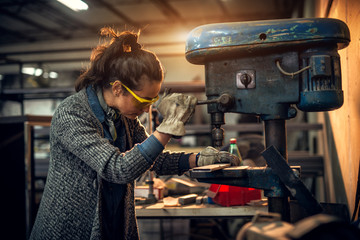 Portrait view of focused serious middle aged professional female carpentry working with an electric...