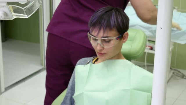 The patient sits in the dental chair and is waiting for the doctor's appointment