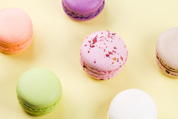 six multicolored macaroons on a yellow background