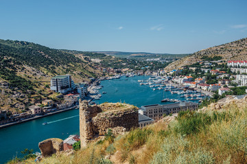 Fototapeta premium Beautiful view of the Black Sea and Balaklava Bay. Panorama view to city, ships and port. View from Cembalo fortress