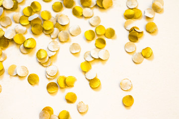 Golden shiny confetti on a white background.