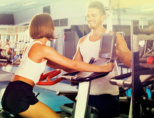 Woman and man using bicycle gym machinery together