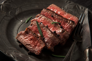 freshly prepared beef sirloin on a dark vintage plate background