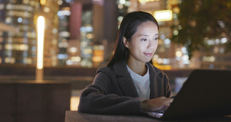 Business woman use of laptop computer and drink of coffee at night